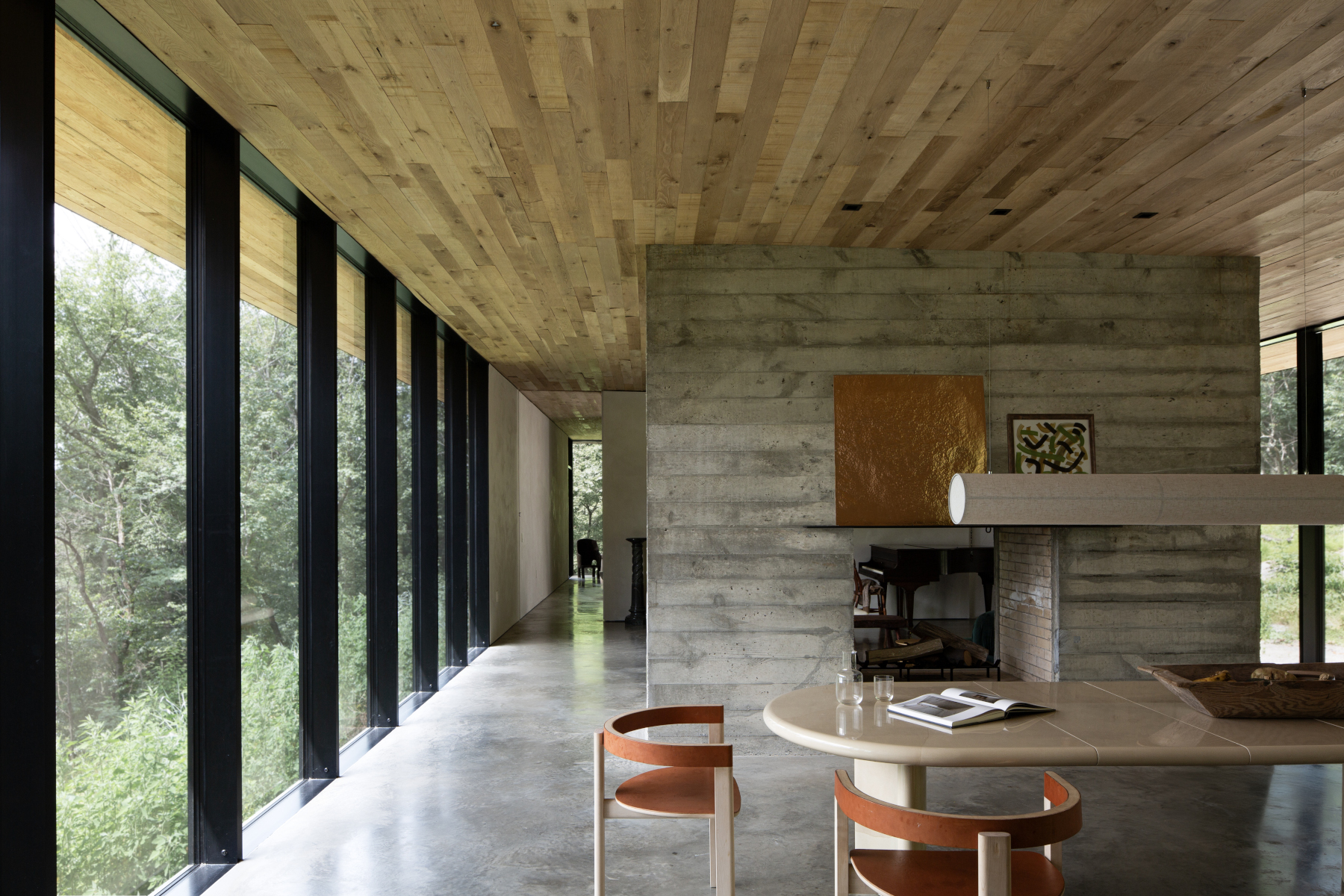 Dining area with board-formed concrete wall and floor-to-ceiling glazing